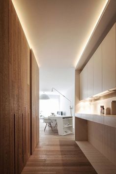 an empty kitchen with wooden cabinets and white counter tops, along with wood flooring