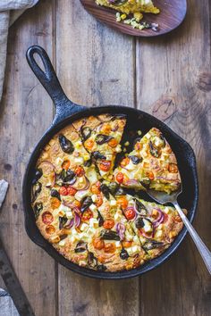 a skillet with a pizza in it on top of a wooden table