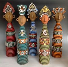 five colorfully painted wooden dolls sitting next to each other