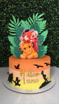 a birthday cake with an image of the lion king on top and leaves around it