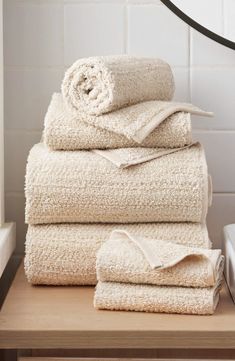 a stack of towels sitting on top of a wooden table