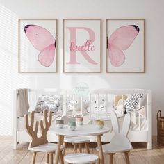 a baby's room with two pink butterfly prints on the wall