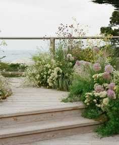 a wooden walkway with flowers and plants on it