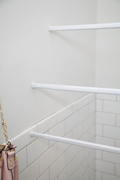 a pink purse hanging from the side of a white wall