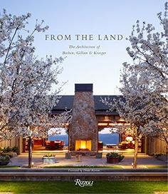 the front cover of a magazine with trees in bloom and lights shining on the house