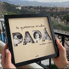 a person holding up a framed photo with the word dad in spanish and pictures of their children