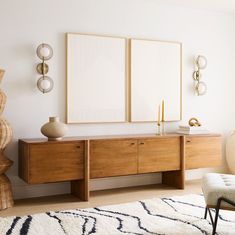 a living room with two framed pictures on the wall and a bench in front of it