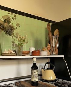 a stove top oven sitting next to a wooden cutting board with utensils on it