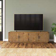 a flat screen tv sitting on top of a wooden cabinet