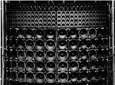 black and white photograph of metal pipes stacked on top of each other in an enclosure