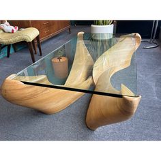 a glass and wood table with an unusual design on the top, in a living room