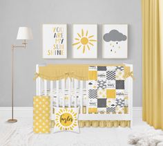 a baby's nursery room with yellow and gray decor on the wall, crib bedding, and pictures