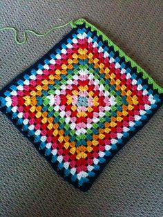 a crocheted square is sitting on the floor