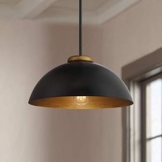 a black and gold pendant light hanging from a ceiling