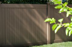 a wooden fence with grass and trees in the background