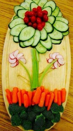 a wooden plate with vegetables and flowers on it