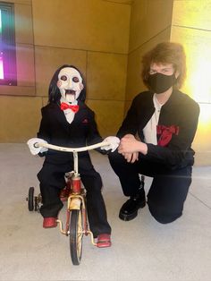 two people wearing masks sitting on a bike