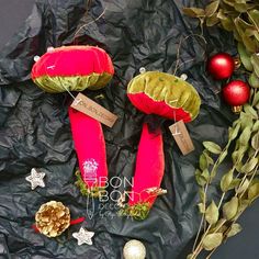 two red stuffed animals sitting on top of a piece of paper next to christmas decorations