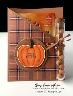 a card with an orange pumpkin on it and some nuts in front of it that says give thanks