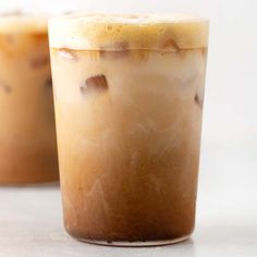 two glasses filled with ice cream sitting on top of a white table next to each other