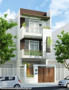 two cars parked on the street in front of a white building with balconies