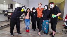 a group of people in costumes standing next to each other with masks on their faces