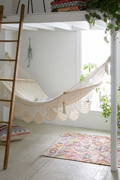 there is a hammock in the room with pink carpet and rugs on the floor