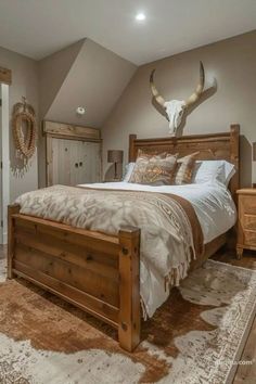 a bedroom with a bed, dressers and an antelope head on the wall