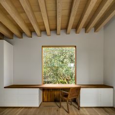 an empty room with wooden ceiling and white cabinets