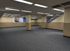 an empty room with no people in it and stairs leading up to the second floor