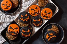 halloween cookies decorated with orange icing and jack - o'- lantern faces on black plates