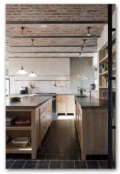 an open kitchen with brick ceiling and wooden cabinets