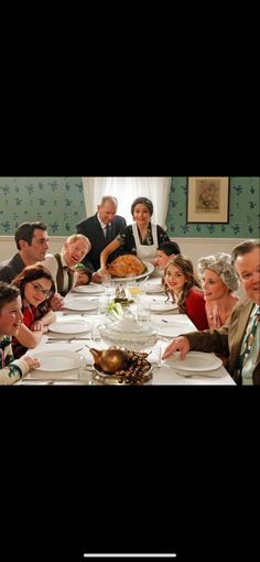 a group of people sitting around a table with plates and food in front of them