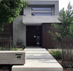 a concrete bench sitting in front of a house