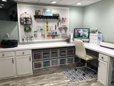 an office cubicle with white cabinets and lots of crafting supplies on the wall