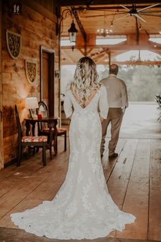 a bride and groom walking into the barn