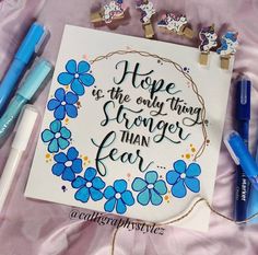 some pens and markers are laying on top of a paper with the words hope is the only thing stronger than fear