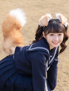 a young woman kneeling down next to a dog on top of a grass covered field