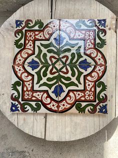 an artisticly designed tile sits on top of a piece of wood