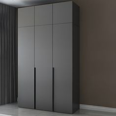 an empty room with two tall gray cupboards next to a window and curtained wall