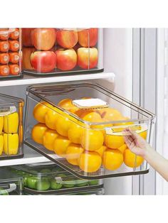 the refrigerator door is open to show fruit and vegetables in plastic bins on shelves