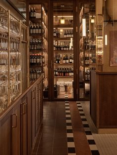 a wine shop with lots of bottles and glasses on the shelves next to each other