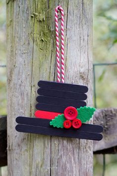 a christmas decoration made out of popsicles on a wooden pole with a candy cane