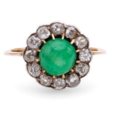 Center Stone: Emerald Cut: Cabochon Cut Weight: Approximately 2 Carats Color: Green Accent Stone: 12 Diamonds Cut: Old Mine Cut Weight: Approximately 1.3 Carats Color: I Clarity: SI Metal: 18K Yellow Gold and Silver Era: Antique  Circa: 1890's Size: 7.5 and can be resized Gram weight: 3.27 This antique ring from the 1890s showcases a captivating cabochon cut emerald at its center, weighing approximately 2 carats and glowing with a rich green hue. Surrounding the emerald are 12 old mine cut diamo Luxury Yellow Gold Cabochon Diamond Ring, Fine Jewelry Emerald Diamond Cabochon Ring, Antique Diamond Cabochon Rings, Luxury Domed Cabochons For Anniversary, Luxury Round Cabochon Diamond Ring, White Gold Cabochon Emerald Ring Fine Jewelry, Yellow Gold Diamond Cabochons Fine Jewelry, White Gold Gemstone Cabochons Fine Jewelry, Fine Jewelry White Gold Cabochon Emerald Ring