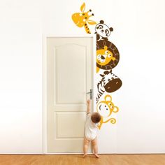 a child reaching up to reach the door with an animal wall sticker on it