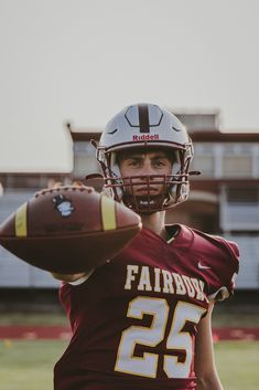 a football player holding a ball in his hand and wearing a helmet with the number 25 on it