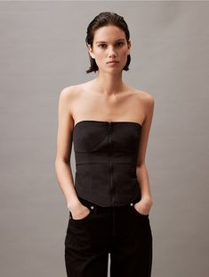 A sleek, fitted silhouette, this bustier is defined with seaming lines for accentuated shape. Created with a zip closure along the front and a structured, padded design. Crafted completely from recycled nylon for reduced environmental impact.  Material: 100% Recycled Nylon. Environmental Impact, Pad Design, Bustier Top, Sleek, Calvin Klein