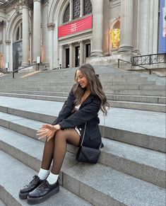 a woman sitting on steps in front of a building