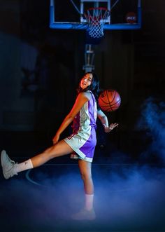 a woman is playing basketball in the dark