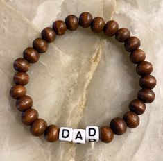 Dad Bracelet - the gift he never knew he needed  Made with wooden beads or 3mm seed beads. Wooden beads are positive intentions beads and have lava rock energy 🌋🌋they are giving all the positive vibes 🌊 Customize bracelet with personalized word or saying and bead colors. See color chart in photos. We have circle and square letters.  CARING TIPS FOR YOUR JEWELRY ⭐️Treat and store with care. ⭐️ For longevity, avoid exposing your jewelry to water. ⭐️ Avoid having direct contact with lotions, per Brown Stretch Bracelet With Letter Beads As Gift, Adjustable Wristband Bracelet For Father's Day, Customize Bracelet, Square Letters, Word Bracelets, Dad Bracelet, Positive Intentions, Customised Bracelets, Stretchy Beaded Bracelet